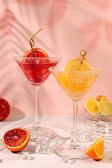 Margarita cocktails with lemon and blood orange, ice cubes, rum and tequila. Summer party and holiday concept. Banner with alcoholic drinks and tropical fruits. Menu for a bar or cafe