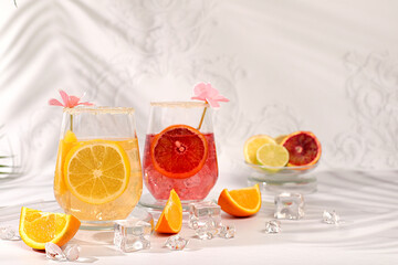 Banner with glasses royal cocktail of blood orange, lemon, yellow orange and ice cubes, rum and...