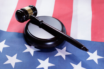 Gavel placed on a base resting an on American flag showcasing patriotism and justice in a courtroom