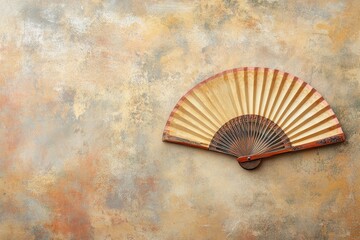 Antique Hand Fan on Textured Background: A Serene, Vintage Still Life