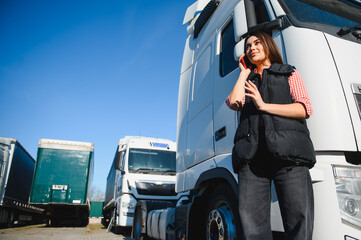 Portrait of a beautiful woman truck driver standing in the parking lot
