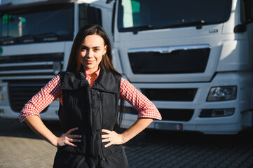 Obraz premium Female truck driver standing in front of her truck after she successfully completed her first tour