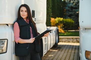 Portrait of a beautiful woman truck driver standing in the parking lot