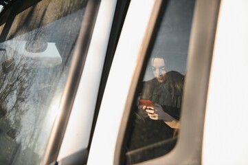 Portrait of trucker sitting in truck cabin with hands on steering wheel