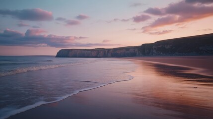 Obraz premium Serene Beach at Sunset with Calm Waves and Soft Clouds Reflecting on Water