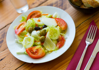 Refreshing salad with chopped tomatoes, sliced lettuce, cucumber and olives