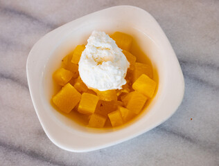 Juicy pineapple cubes with sweet ice cream served on plate