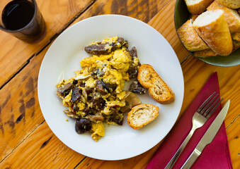 Appetizing omelet with with mushrooms and blood sausage served on plate