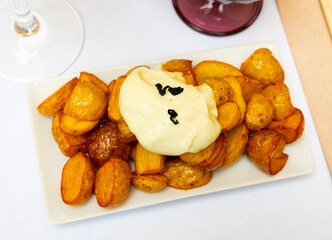 Traditional Spanish potato tapa Patatas bravas with spicy creamy sauce ..