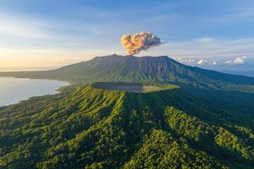 Volcano erupts in dense forest landscape with plume of ash rising against a clear sky