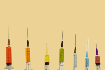 Medical syringes with medicine on beige background