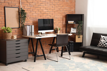 Interior of modern office with workplace, shelf unit and drawers