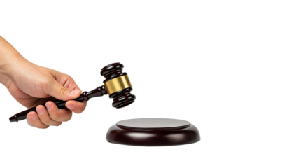 A hand holds a dark brown wooden gavel with a gold band, about to strike a matching sounding block on a transparent background.