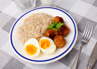 Breakfast with scrumble egg and oatmeal and meatballs