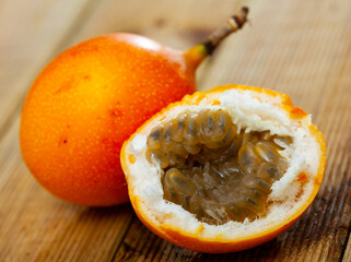 Fresh sweet granadilla whole and halves on wooden table. Healthy vitamin product