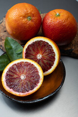 Sicilian sweet juicy yellow and red blood oranges with green leaves close-up