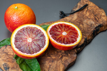 Sicilian sweet juicy yellow and red blood oranges with green leaves close-up
