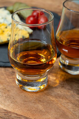Whiskey and cheese pairing, tasting whisky glasses and plate with sliced crumbly old blue stilton and blue shropshire cheeses, Great Britain food and drink