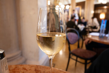Lifestyle of beautiful Vienna, glass of cold white dry Austrian wine served in old Viennese-style...