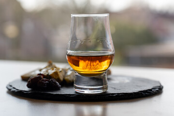 Whiskey and cheese pairing, tasting whisky glass and plate with sliced blue stilton and blue shropshire cheeses, Great Britain food and drink