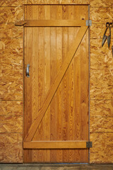 Puerta de madera antigua tipo establo con herramienta