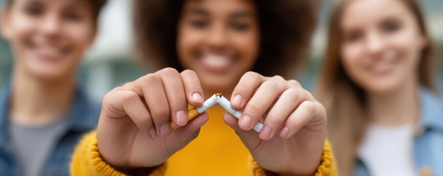 Anti-smoking concept. Young Diverse Group of Friends Breaking Cigarette to Promote Smoking Cessation and Healthy Lifestyle - Powered by Adobe