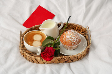 Tray with breakfast and rose for Valentine's Day on bed