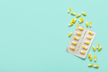 Hard capsules in blister pack on turquoise background