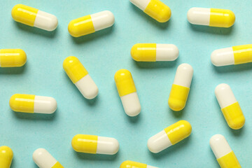 Many hard capsules on turquoise background