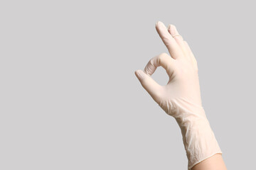 Fototapeta premium Doctor's hand in medical glove showing OK on light background
