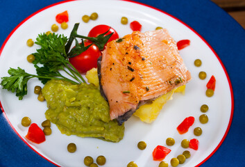 Image of tasty fried trout fillet served mashed potatoes, guacamole and greens on plate