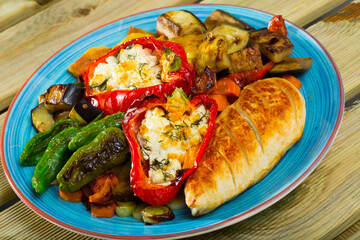 Plate with baked vegetables, stuffed red peppers and grilled chicken fillet