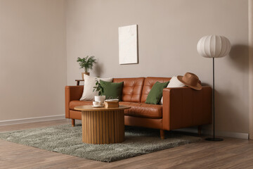 Obraz premium Brown leather sofa with wooden table and floor lamp near grey wall in living room