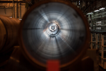 Close-up view through the interior of a large metal gas pipeline in an industrial facility