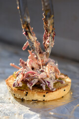 Burger bun with coleslaw and pickles during preparation