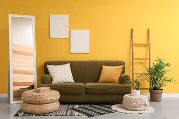 Beautiful interior of room with sofa, pouf and floor mirror