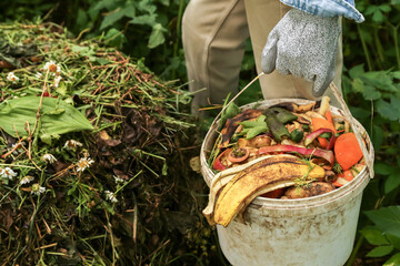 Zero waste, composting concept. Compost heap pile with bio waste close-up. Farmer hands put weeds...