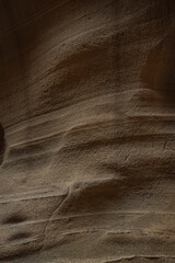 Sunlight highlights the smooth lines and curves of a sandstone wall, creating an abstract pattern