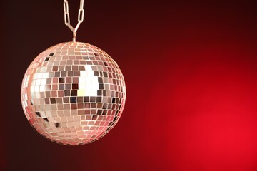 Shiny disco ball on red gradient background. Space for text