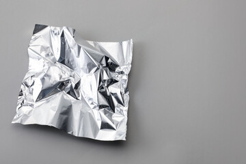 Piece of crumpled aluminum foil on light grey background, top view. Space for text