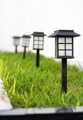 hilera de lámparas solares de estaca en el pasto verde