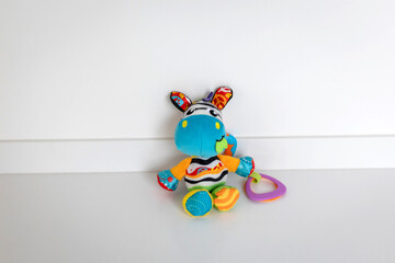 Naklejka premium Colorful Stuffed Animal Toy Holding a Ring with Patterned Ears and Multicolored Body