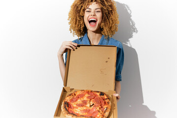 Joyful young woman holding a pizza box with a delicious pizza, showcasing her vibrant personality and enthusiasm for food