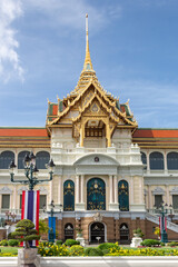 Iconic Grand Palace Throne Hall building and Thailand flag located in Bangkok, Thailand. Photo taken on a cloudy day