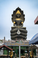 Obraz premium Lopburi, Thailand, April 14, 2025, Giant Buddha statue at Wat Tamtako, captivating visitors