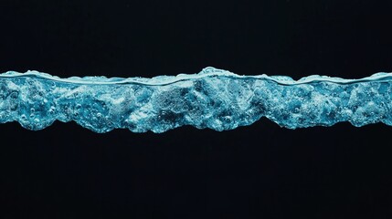 A close-up view of water waves, showcasing clear blue tones and bubbles against a dark background.