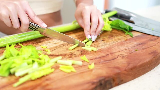 Chopping Celery on Wooden Cutting Board in Kitchen