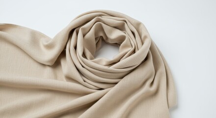 A beige fabric is draped and swirled on a white surface creating soft folds and a central vortex look