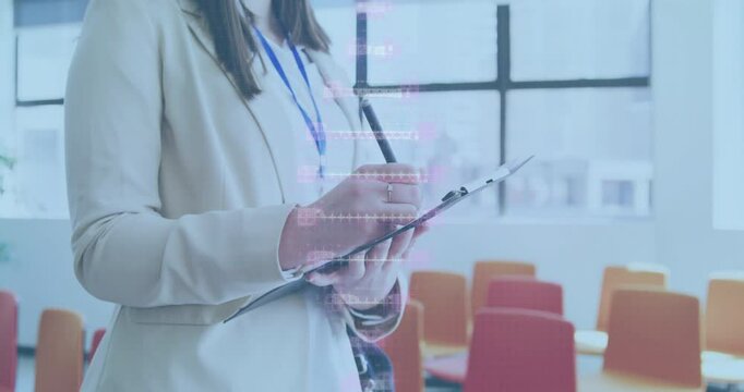Business woman writing notes in training room, with animated data charts floating around window