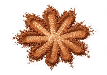 Brown powder arranged in a floral pattern on a white background with textured lines and scattered grains